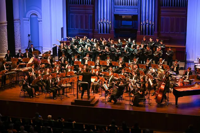 Full VENTUS wind orchestra under blue lights at the Victoria Concert Hall